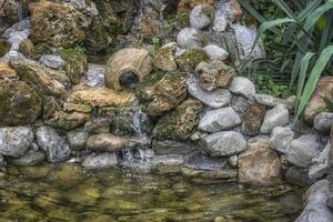 fonte de pedra decorativa com um pote foto