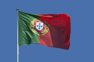 Português bandeira acenando no topo do Está pólo foto