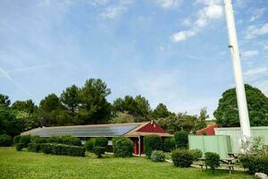 uma pequeno vermelho casa com solar painéis em a cobertura foto