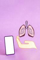 mão mostrar pulmões figura e inteligente telefone com em branco tela. foto