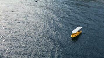 aéreo Visão do amarelo pescaria barco dentro a mar foto