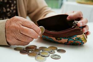 idosa aposentada contando dinheiro de moedas e se preocupa com despesas mensais e pagamento de taxa de tratamento. foto