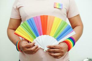 mulher asiática com bandeira do arco-íris, direitos do símbolo lgbt e igualdade de gênero, mês do orgulho lgbt em junho. foto