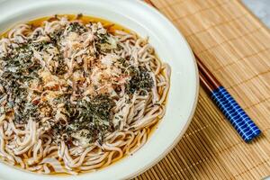 coreano Comida naengmemilguksu, uma inverno delicadeza, isto trigo sarraceno macarrão prato é servido dentro uma frio frango- ou à base de carne caldo e coberto com frio fatias do carne e ovo Como uma guarnição, enfeite, adorno. foto