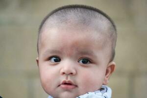 fofa ásia paquistanês bebê Garoto é posando dentro a casa jardim durante nublado dia sobre Luton, Inglaterra Reino Unido. imagem estava capturado em Julho 23, 2023 foto