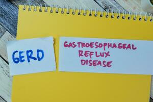 conceito do gerd - gastroesofágico refluxo doença escrever em pegajoso notas isolado em de madeira mesa. foto