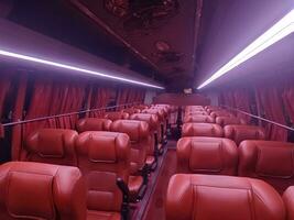 profundo vermelho cor interior do viagem ônibus com iluminação efeito.turista ônibus assento interior iluminação. foto