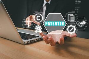 patente conceito, pessoa mão segurando patenteado ícone em virtual tela, patente direito autoral lei o negócio tecnologia conceito. foto