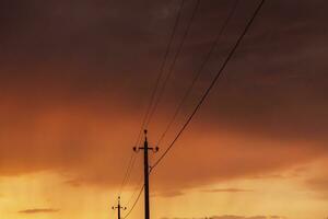alta voltagem poder linhas às pôr do sol. eletricidade distribuição estação. eletricidade postes em a fundo do a céu foto