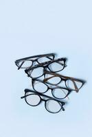 Óculos em azul fundo com cópia de espaço. ótico loja, visão teste, à moda óculos conceito. vertical formatar. foto