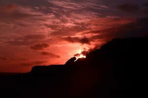 tumultuado Rosa céu sobre vulcânico Rocha dentro Aruba foto