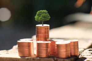 pilha de moedas no fundo da mesa e economizando dinheiro e conceito de crescimento de negócios, finanças e investimento foto