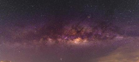 Cenário noturno com a Via Láctea colorida e amarela clara cheia de estrelas no céu no verão belo universo de fundo do espaço foto