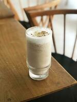 uma vidro do leite café com régio bolacha cobertura em uma mesa foto