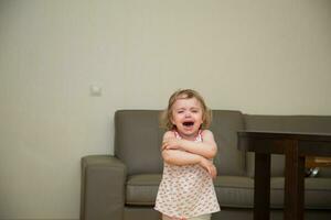 uma pequeno menina é chorando dentro uma quarto foto