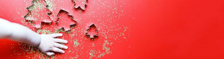 bandeira a criança faz Natal biscoitos. criança é mão segurando uma bolacha cortador foto