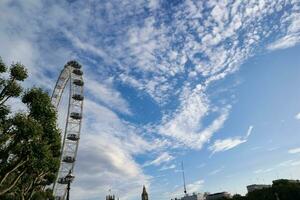 lindo baixo ângulo Visão do Londres olho, a partir de histórico grande ben relógio torre rio Tamisa, às Westminster central Londres, Inglaterra ótimo Grã-Bretanha, Reino Unido. imagem capturado durante nublado dia do agosto 2º, 2023 foto
