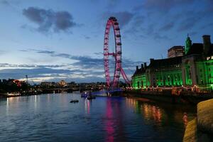 a maioria lindo cenas do iluminado Londres olho a partir de rio Tamisa Westminster, grande ben relógio torre às depois de pôr do sol noite. Inglaterra ótimo Grã-Bretanha, cenas estava capturado em agosto 02, 2023 depois de pôr do sol. foto