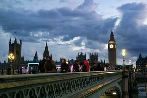 lindo cenas do iluminado britânico estrada às Londres olho a partir de rio Tamisa Westminster, grande ben relógio torre às depois de pôr do sol noite. Inglaterra ótimo Grã-Bretanha, cenas estava capturado em agosto 02, 2023 foto