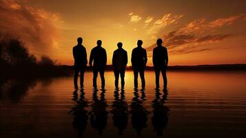 homens s silhuetas ao lado a lago durante pôr do sol foto