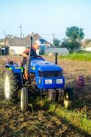 kherson oblast, Ucrânia - setembro 19, 2020 uma agricultor em uma trator com a agregar do equipamento para escavação batata. agricultura. agrícola trabalhos dentro a campo. campanha colheita batatas dentro outono. foto