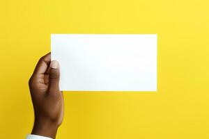 uma humano mão segurando uma em branco Folha do branco papel ou cartão isolado em amarelo fundo. ai gerado foto