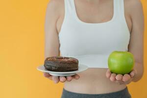 fino corpo mulheres escolher durante verde maçã e chocolate rosquinha, fêmea escolher verde maçã para dieta. Boa saudável Comida. peso perder, equilíbrio, ao controle, reduzir gordo, baixo calorias, rotinas, exercício. foto