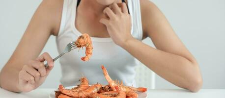 Comida alergias, mulheres ter reações comichão e vermelhidão depois de comendo camarão, frutos do mar alergia, coceira, irritação na pele, abdominal dor, diarréia, peito aperto, inconsciência, morte, forte evitar alergias foto