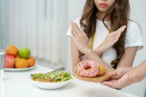 dieta e dieta. corpo feminino magro de beleza confunde rosquinha. mulher em roupas de ginástica atinge meta de perda de peso para uma vida saudável, louca por magreza, cintura fina, nutricionista. foto