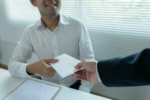 os empresários recebem salário ou bônus da administração ou do chefe. empresa dar recompensas para incentivar o trabalho. empresário sorridente desfrutando de uma recompensa na mesa do escritório. foto