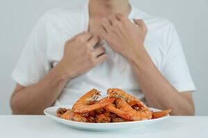 Comida alergias, mulheres ter reações comichão e vermelhidão depois de comendo camarão, frutos do mar alergia, coceira, irritação na pele, abdominal dor, diarréia, peito aperto, inconsciência, morte, forte evitar alergias foto