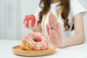 dieta e dieta. corpo feminino magro de beleza confunde rosquinha. mulher em roupas de ginástica atinge meta de perda de peso para uma vida saudável, louca por magreza, cintura fina, nutricionista. foto