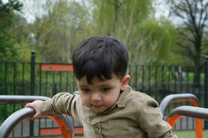 fofa ásia paquistanês bebê é desfrutando a lindo ensolarado dia às Wardown crianças e público parque do luton Cidade do Inglaterra Reino Unido. baixo ângulo imagem estava capturado em abril 03, 2023 foto