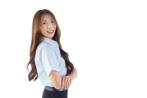 retrato do adulto tailandês aluna dentro universidade aluna uniforme. jovem ásia fofa menina em pé com dela braços cruzado com confiança enquanto isolado em branco fundo. foto