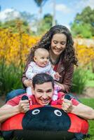 jovem pais tendo Diversão ao ar livre com seus seis meses velho bebê garota. felicidade conceito. família conceito foto