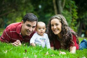 jovem pais tendo Diversão ao ar livre com seus seis meses velho bebê garota. felicidade conceito. família conceito foto