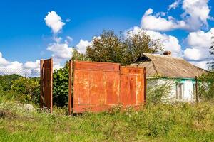 linda e velha casa de fazenda abandonada na zona rural em fundo natural foto