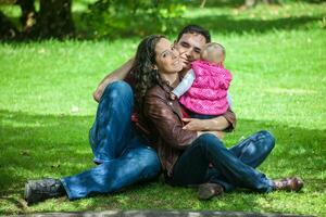 jovem pais tendo Diversão ao ar livre com seus seis meses velho bebê garota. felicidade conceito. família conceito foto