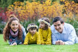 família do quatro tendo Diversão ao ar livre dentro uma lindo ensolarado dia às a parque. felicidade conceito. família conceito. foto