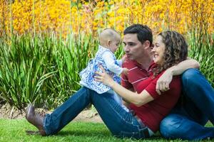 jovem pais tendo Diversão ao ar livre com seus seis meses velho bebê garota. felicidade conceito. família conceito foto