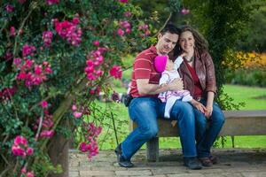 jovem pais tendo Diversão ao ar livre com seus seis meses velho bebê garota. felicidade conceito. família conceito foto