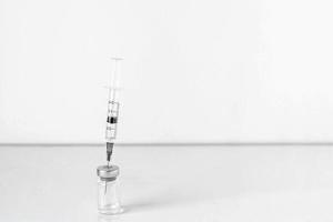 agulha de seringa em frasco com vacina de coronavírus foto