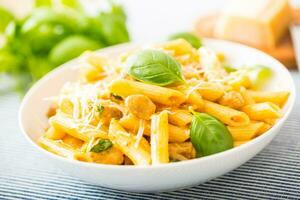 massa Macarrão Penne com frango peças cogumelos manjericão parmesão queijo e branco vinho. italiano Comida dentro branco prato em cozinha mesa foto