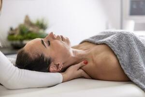 cliente deitado em costas pega ombros massagem de uma profissional massagista dentro a estúdio foto