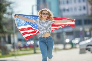 atraente feliz jovem menina com a bandeira do a Unidos estados do América foto