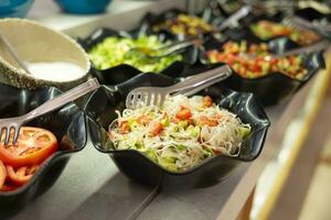 saladas com fresco legumes dentro taças em a bufê mesa dentro a hotel restaurante foto