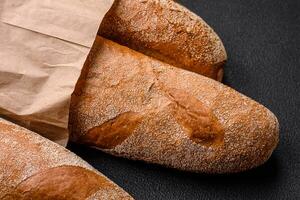 francês baguete pão em uma Sombrio texturizado concreto fundo foto