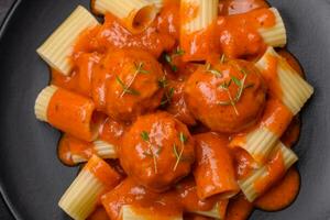 delicioso fresco almôndegas e massa dentro tomate molho com sal, especiarias e ervas foto