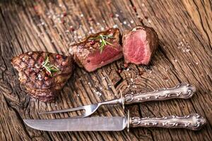 grelhado carne bife com alecrim, sal e Pimenta em velho corte borda. carne filé mignon bife. foto