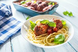 delicioso italiano refeição carne carne bolas com massa espaguete e manjericão dentro branco placa. foto